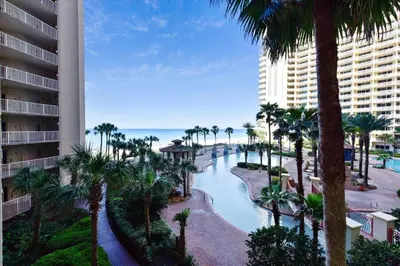 a view of a resort with palm trees and a river at Shores of Panama 325 - 3rd Floor, Updated, Free Fun! Sleeps 6, condo in Panama City Beach