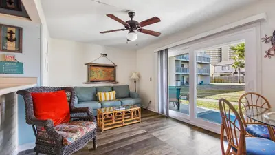 a living room with a couch and a ceiling fan at Endless Summer #C4 by Nautical Properties Vacation Rentals in Panama City Beach