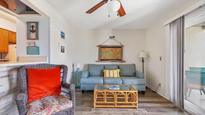 a living room with a blue couch and a table at Endless Summer #C4 by Nautical Properties Vacation Rentals in Panama City Beach