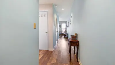 a hallway with white walls and a hallway with a table at Endless Summer #C4 by Nautical Properties Vacation Rentals in Panama City Beach
