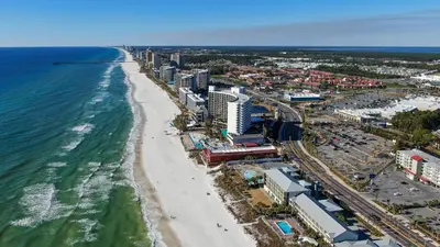 an aerial view of a beach and the ocean at Compass Cove at Gulf Highlands by Nautical Properties Vacation Rentals in Panama City Beach