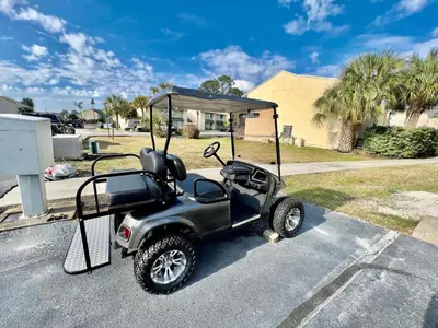a golf cart with a canopy on the street at Compass Cove at Gulf Highlands by Nautical Properties Vacation Rentals in Panama City Beach