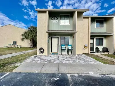 a house with a table and chairs in front of it at Compass Cove at Gulf Highlands by Nautical Properties Vacation Rentals in Panama City Beach