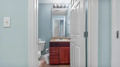 a bathroom with a sink and a toilet and a mirror at Laketown Wharf #101 by Nautical Properties Vacation Rentals in Panama City Beach