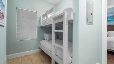 a bunk bed room with a white bunk bed in a bedroom at Laketown Wharf #101 by Nautical Properties Vacation Rentals in Panama City Beach