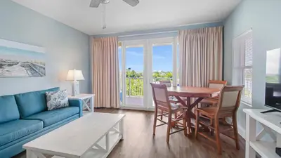 a living room with a blue couch and a table and chairs at Laketown Wharf #101 by Nautical Properties Vacation Rentals in Panama City Beach
