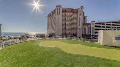 a golf course on the beach with buildings and the ocean at Laketown Wharf #101 by Nautical Properties Vacation Rentals in Panama City Beach