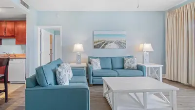 a living room with a blue couch and a table at Laketown Wharf #101 by Nautical Properties Vacation Rentals in Panama City Beach