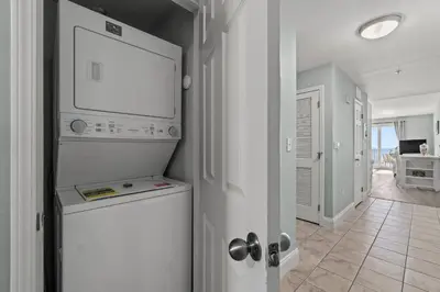 a kitchen with a washer and dryer in a room at Living Right at Laketown Wharf #1016 by Nautical Properties in Panama City Beach