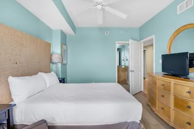 a bedroom with a bed and a flat screen tv at Grandview East 301 in Panama City Beach