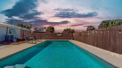 a swimming pool in front of a wooden fence at Private Pool - Steps To Beach - Fenced Backyard - FLPCB74 in Panama City Beach