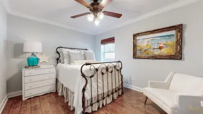 a bedroom with a bed with a ceiling fan and a chair at Private Pool - Steps To Beach - Fenced Backyard - FLPCB74 in Panama City Beach
