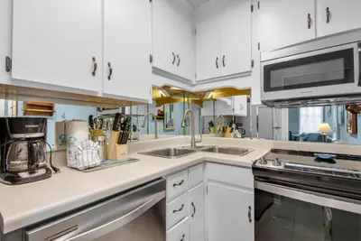 a white kitchen with a sink and a microwave at Horizon South 51B in Panama City Beach