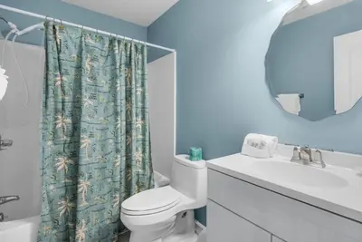 a bathroom with a toilet and a sink and a mirror at Horizon South 51B in Panama City Beach