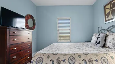 a bedroom with a bed and a dresser and a television at Laketown Wharf #1211 by Nautical Properties Vacation Rentals in Panama City Beach