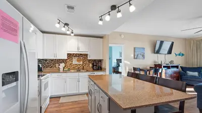 a kitchen with white cabinets and a counter top at Laketown Wharf #1211 by Nautical Properties Vacation Rentals in Panama City Beach