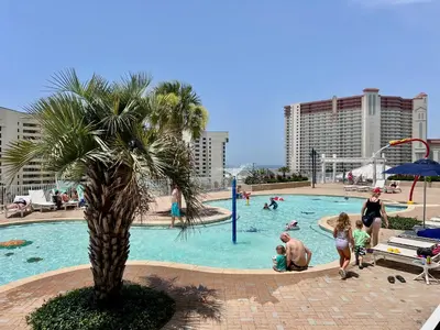 a family playing in a swimming pool at a resort at Stunning Ocean Views! Resort Beach Condo! Sleeps 8! by Dolce Vita Getaways PCB in Panama City Beach