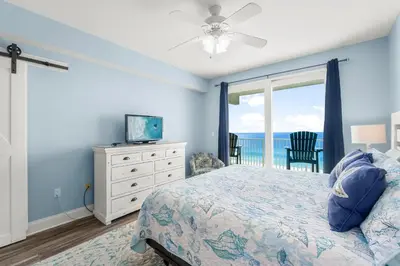 a bedroom with a bed and a tv and a window at Stunning Ocean Views! Resort Beach Condo! Sleeps 8! by Dolce Vita Getaways PCB in Panama City Beach
