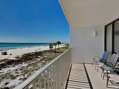 a balcony with chairs and a view of the beach at Edgewater Leeward #206 in Panama City Beach