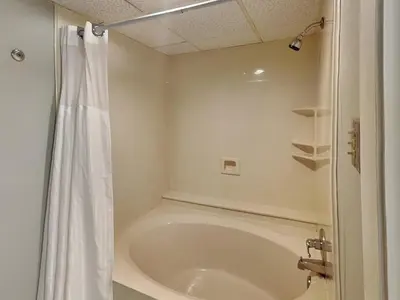 a white bathroom with a shower and a tub at Edgewater Leeward #206 in Panama City Beach