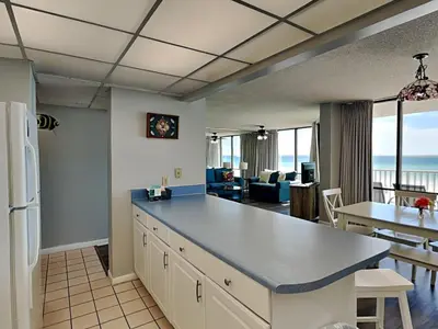 a kitchen and living room with a view of the ocean at Edgewater Leeward #206 in Panama City Beach