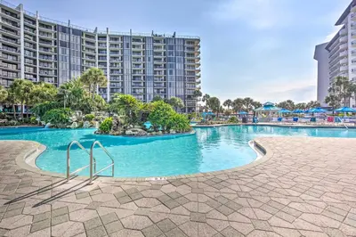 a swimming pool at a resort with buildings in the background at PCB Vacation Rental with Sweeping Ocean Views! in Panama City Beach