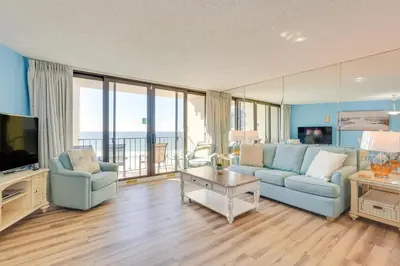a living room with two blue couches and a television at PCB Vacation Rental with Sweeping Ocean Views! in Panama City Beach