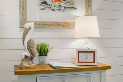 a table with a lamp and a picture on it at Sunbird Resort! Direct Beachfront Condo! Free Beach Chairs! by Dolce Vita Getaways PCB in Panama City Beach