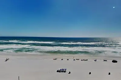 a group of people on a beach near the ocean at Grandview East #703 in Panama City Beach