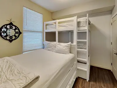 a bedroom with a white bunk bed next to a window at Grandview East #703 in Panama City Beach