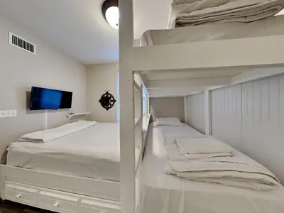 a bedroom with two bunk beds and a flat screen tv at Grandview East #703 in Panama City Beach