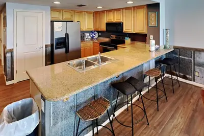 a kitchen with a large island with bar stools at Grandview East #703 in Panama City Beach
