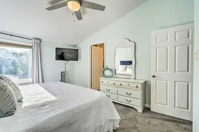 a bedroom with a bed and a dresser with a mirror at Pool and Beach Access Sunnyside 55 in PCB! in Panama City