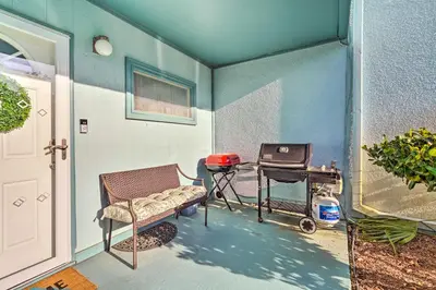 a patio with a grill and a chair and a table at Pool and Beach Access Sunnyside 55 in PCB! in Panama City