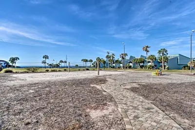 a dirt road with palm trees and a building at Pool and Beach Access Sunnyside 55 in PCB! in Panama City