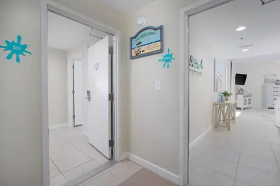 a hallway with a door leading into a room at Water Park On-Site! 2 Beachfront Master Suites! Corner Balcony Views! in Panama City Beach