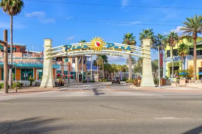 a city street with a carnival arch with palm trees at Water Park On-Site! 2 Beachfront Master Suites! Corner Balcony Views! in Panama City Beach