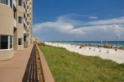a sandy beach next to a building and the ocean at CORNER UNIT! Beach Views! FREE WIFI! 3-Bed, 3-Bath! Sleeps 9! in Panama City Beach