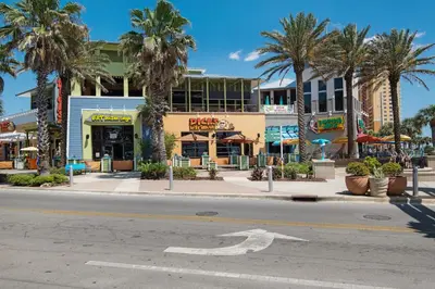 an empty street in front of a building with palm trees at CORNER UNIT! Beach Views! FREE WIFI! 3-Bed, 3-Bath! Sleeps 9! in Panama City Beach