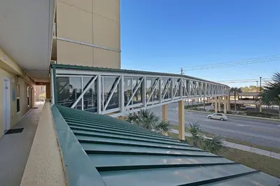a building with a glass walkway next to a street at Beautiful Ocean Views! 2-Bedroom, 2-Bathroom! Resort Pools! in Panama City Beach