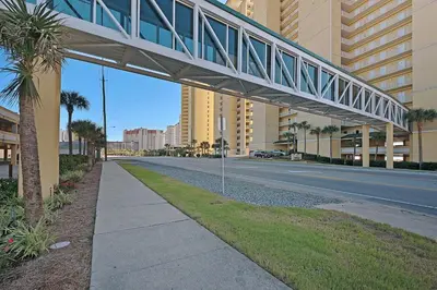 a walkway over a street in a city with buildings at Beautiful Ocean Views! 2-Bedroom, 2-Bathroom! Resort Pools! in Panama City Beach