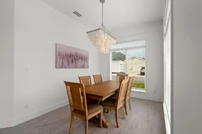 a dining room with a wooden table and chairs at Brand NEW Expansive Coastal Home w/ Custom Furnishings Sleeps 15 in Panama City Beach