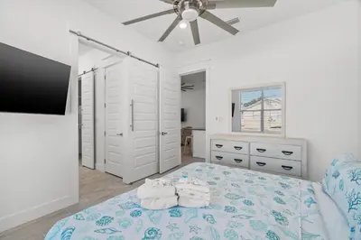 a bedroom with a bed with towels on it at Brand NEW Expansive Coastal Home w/ Custom Furnishings Sleeps 15 in Panama City Beach
