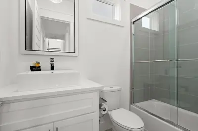 a bathroom with a sink and a toilet and a shower at Brand NEW Expansive Coastal Home w/ Custom Furnishings Sleeps 15 in Panama City Beach