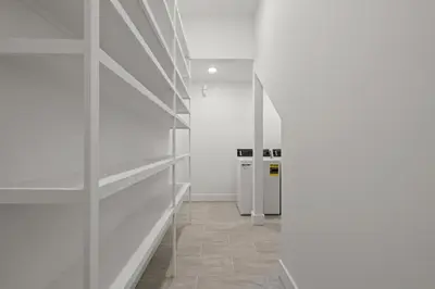 a hallway with white shelves in a white room at Brand NEW Expansive Coastal Home w/ Custom Furnishings Sleeps 15 in Panama City Beach