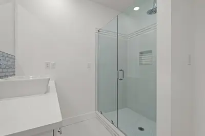 a white bathroom with a glass shower stall at Brand NEW Expansive Coastal Home w/ Custom Furnishings Sleeps 15 in Panama City Beach