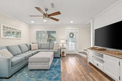 a living room with a couch and a flat screen tv at 140 Feet To White Sandy Beaches! Newly Renovated! Pool! Grill! in Panama City Beach