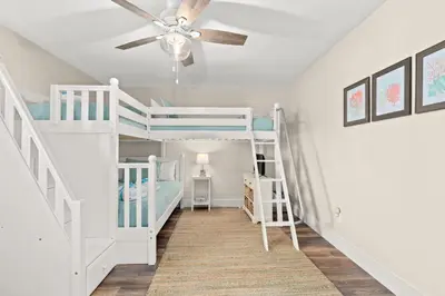 a room with two bunk beds and a ceiling fan at 140 Feet To White Sandy Beaches! Newly Renovated! Pool! Grill! in Panama City Beach
