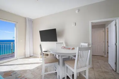 a dining room with a table and chairs and a television at Penthouse! Beautiful Views! Newly Remodeled and Listed! in Panama City Beach