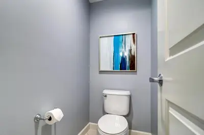 a bathroom with a toilet and a painting on the wall at Gulf Front Master Suite! Directly On The Beach! 3 BR / 2 BA! Sleeps 8! in Panama City Beach